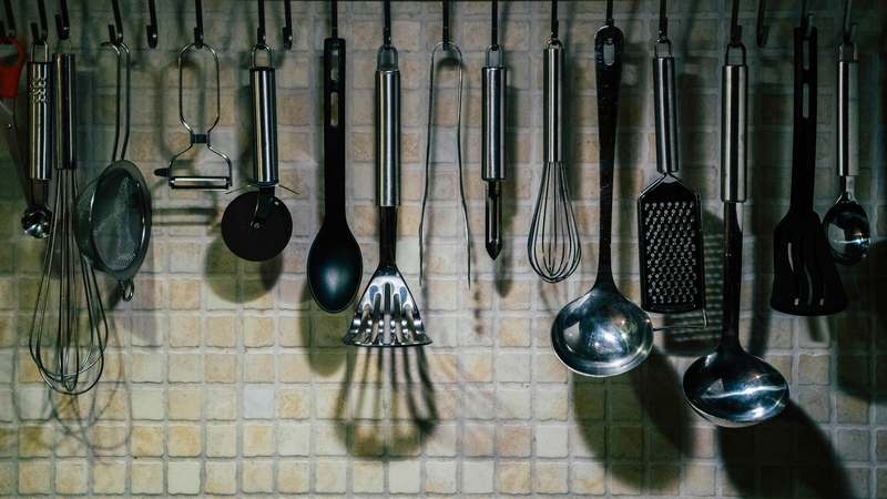 Assorted high-quality manual and electric spice grinders on a rustic wooden kitchen counter